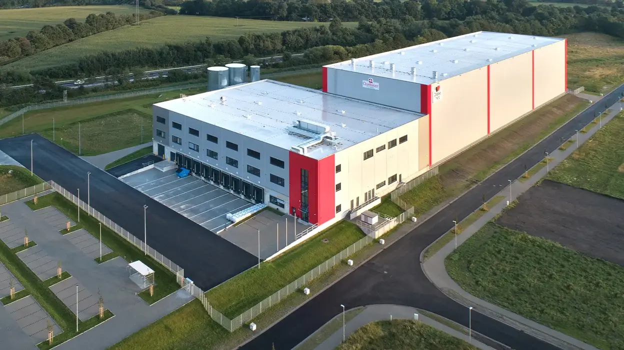 Luftaufnahme des Queisser-Logistikzentrums Stand September 2019 mit Ladebereichen, leerem Parkplatz und umliegender Grünfläche 