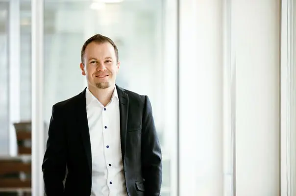 Mann im schwarzen Sakko im Büro