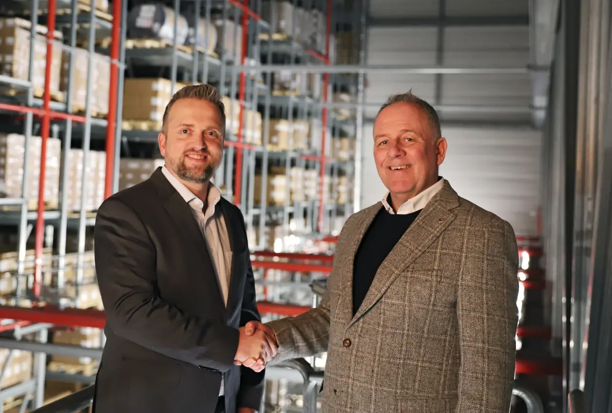 Axel Kaempfe (Geschäftsführer Queisser Pharma) und Thomas Rasmussen (Bürgermeister Handewitt) geben sich die Hand in einem Hochregallager 