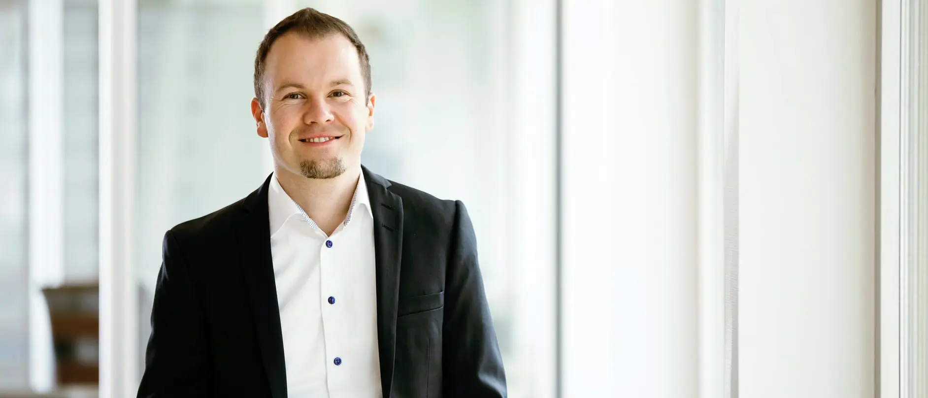 Mann im schwarzen Sakko im Büro
