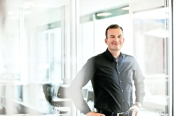 Mann im dunklen Hemd in hellem Büro