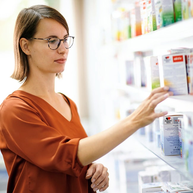 Frau am Regal mit Queisser Produkten